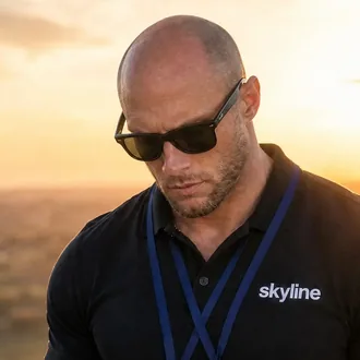 Neil, Founder and Chief Pilot of Skyline Visuals, flying a drone at sunset