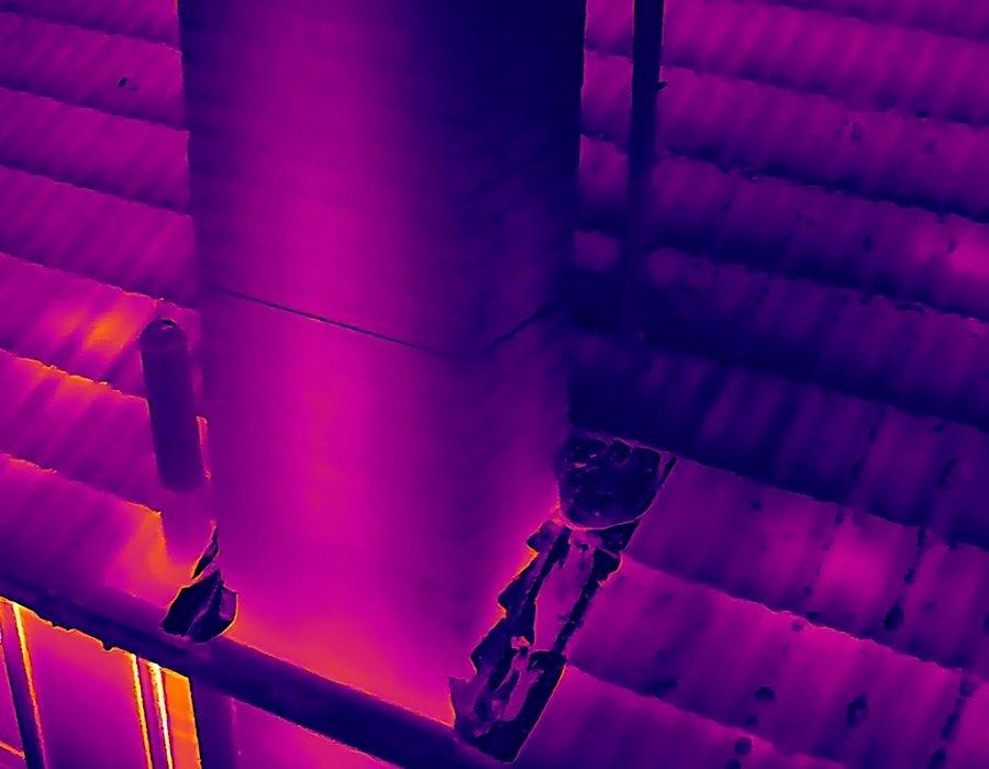 Radiometric thermal image of same chimney junction — heat signatures invisible to standard cameras