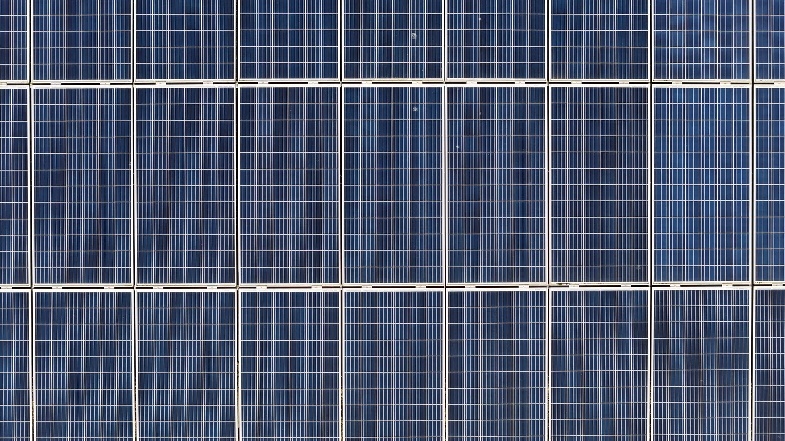 Close top-down aerial view of a solar panel array in good condition, showing cell-level clarity at 48MP